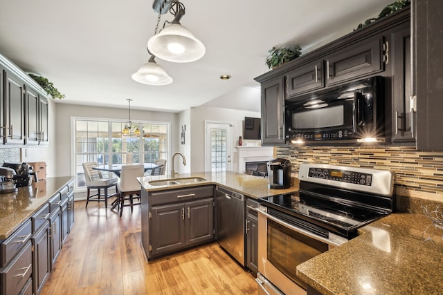 kitchen featuring pendant lighting, sink, dark brown cabinets, appliances with stainless steel finishes, and light hardwood / wood-style floors