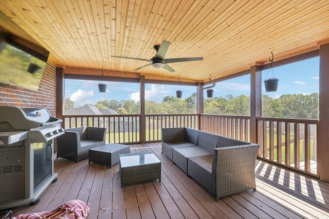 sunroom featuring ceiling fan and wooden ceiling