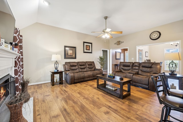 living room featuring ceiling fan, lofted ceiling, and light hardwood / wood-style flooring