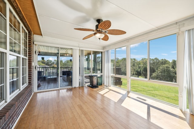 unfurnished sunroom with ceiling fan