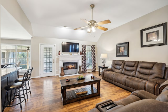 living room with ceiling fan, hardwood / wood-style flooring, and lofted ceiling