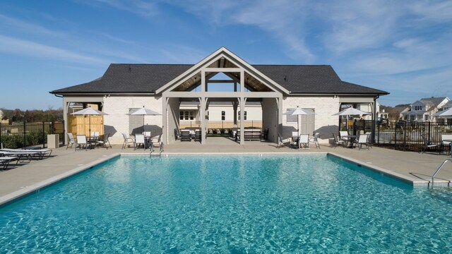 back of house with a community pool and a patio