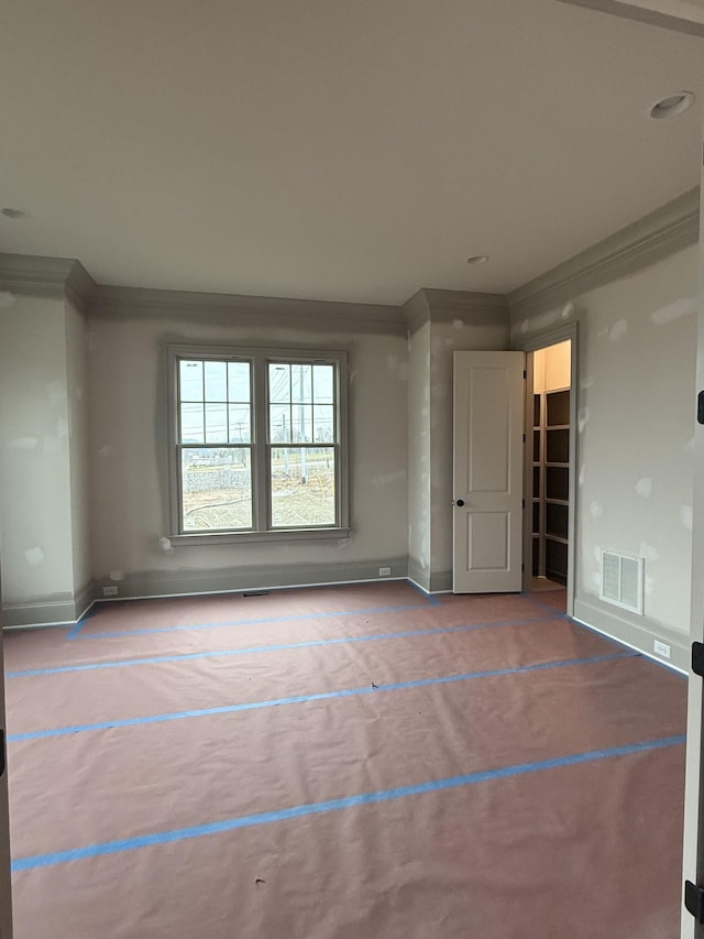 unfurnished room featuring crown molding