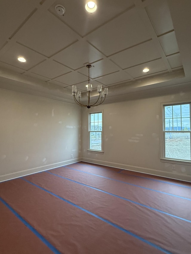 empty room with a notable chandelier and coffered ceiling