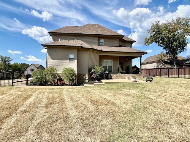 back of house with a yard, a patio, and an outdoor fire pit