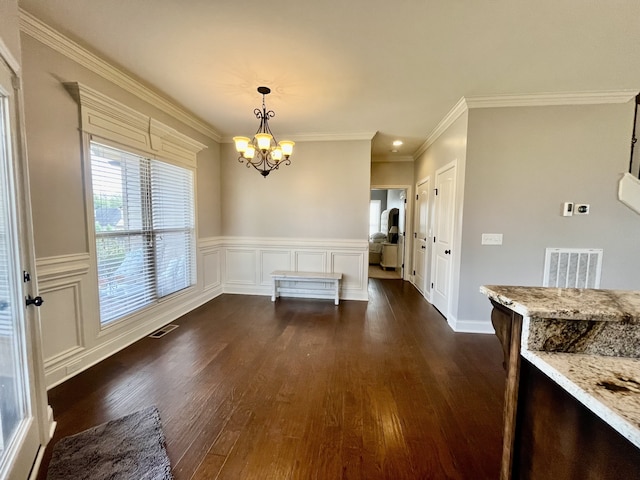 unfurnished dining area with crown molding, dark wood-type flooring, and a notable chandelier