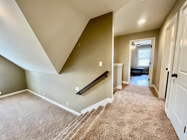 interior space featuring light carpet, vaulted ceiling, and ceiling fan