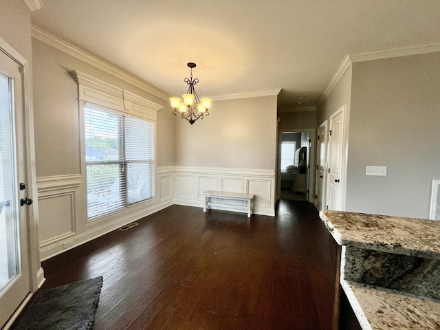 unfurnished dining area featuring a notable chandelier, dark hardwood / wood-style flooring, and ornamental molding