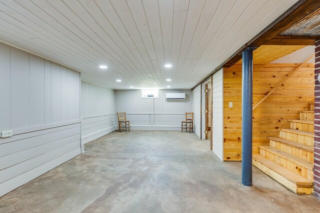 basement featuring wooden walls, wooden ceiling, and a wall mounted AC