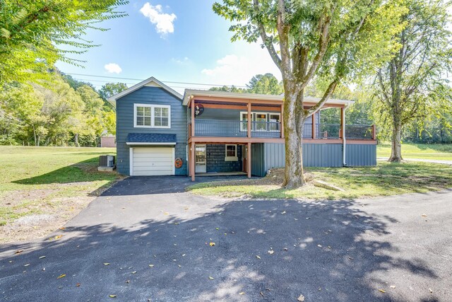 view of front of house featuring a front yard, a garage, a deck, and central AC unit