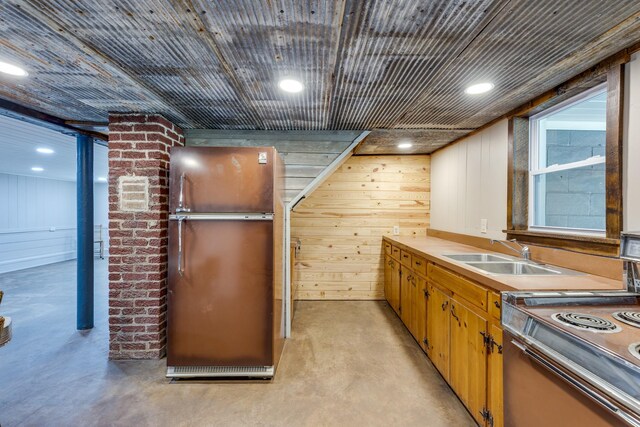 kitchen with wooden walls, sink, and stainless steel appliances