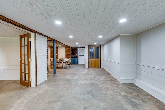 spare room with wooden walls, wooden ceiling, and concrete floors