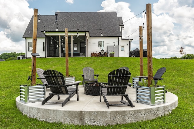 rear view of house with a lawn, a patio, and a fire pit