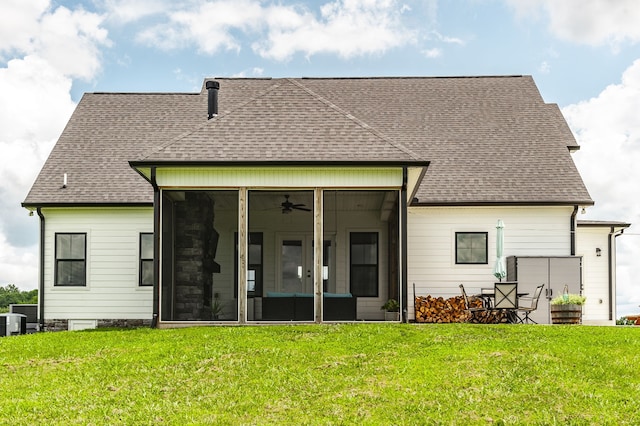 back of house with ceiling fan, a sunroom, and a lawn