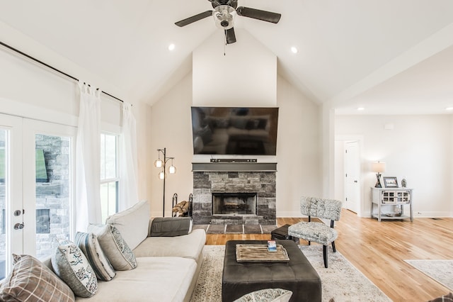 living room featuring wood-type flooring, a fireplace, high vaulted ceiling, and ceiling fan