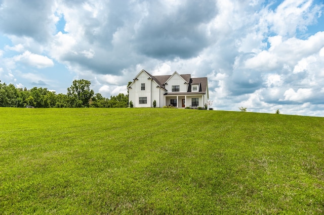 view of front of house featuring a rural view and a front lawn