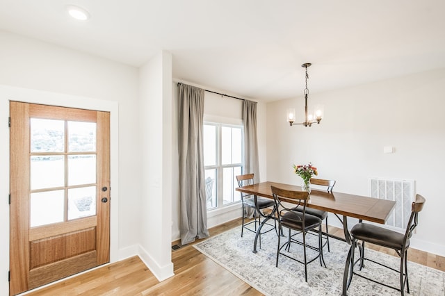 dining room featuring light hardwood / wood-style flooring and a chandelier