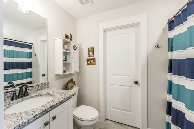 bathroom with curtained shower, vanity, and toilet