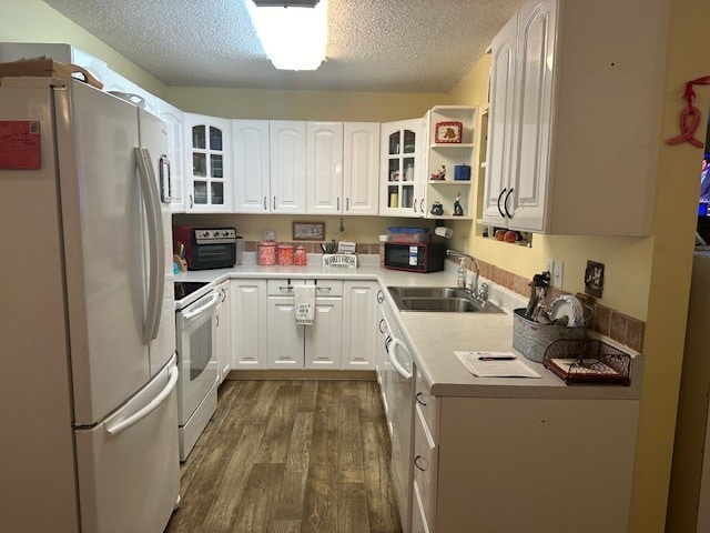 kitchen featuring white appliances, dark wood-type flooring, sink, white cabinets, and a textured ceiling