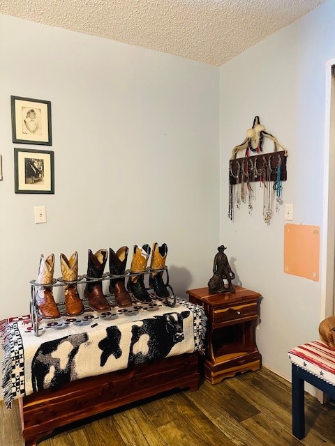 bedroom with a textured ceiling and dark hardwood / wood-style floors