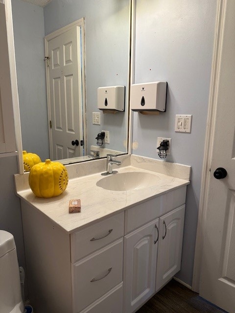 bathroom with vanity, toilet, and hardwood / wood-style flooring