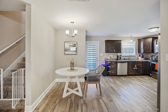 dining space featuring light hardwood / wood-style flooring, a chandelier, and plenty of natural light