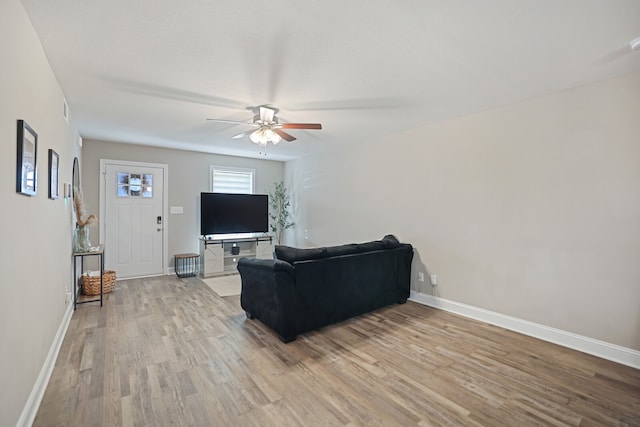 living room with light wood-type flooring and ceiling fan