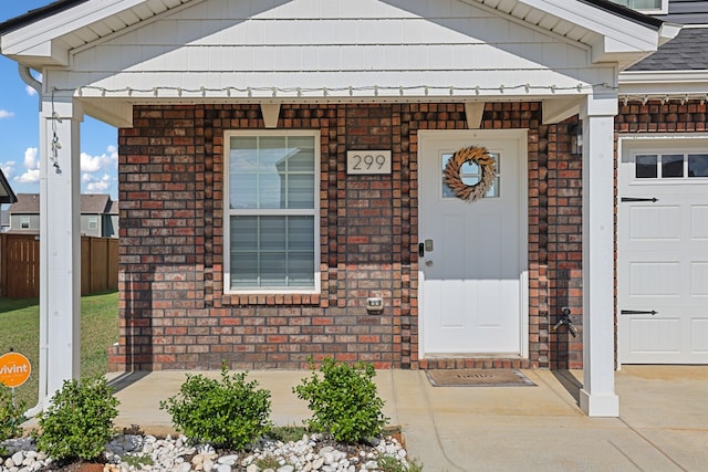 view of exterior entry featuring a garage and a porch