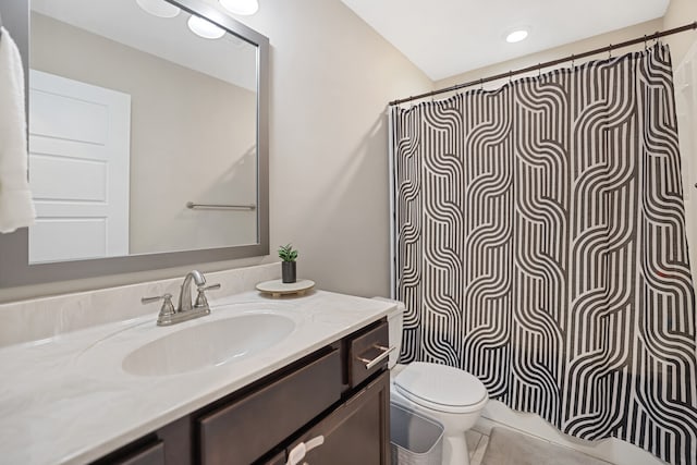 bathroom featuring curtained shower, tile patterned flooring, vanity, and toilet