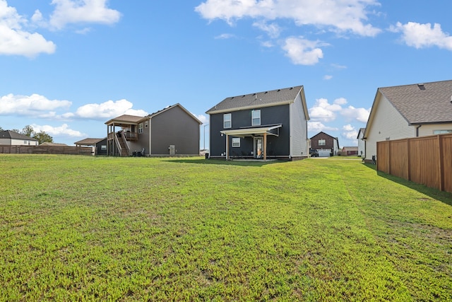 rear view of property featuring a yard