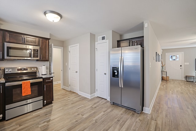 kitchen with light wood-type flooring, light stone countertops, dark brown cabinets, and stainless steel appliances