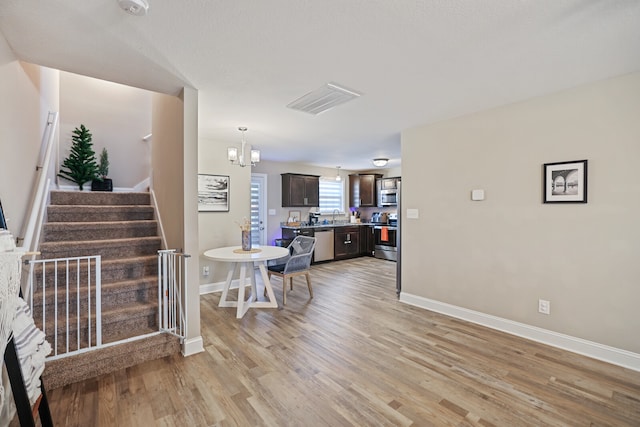 interior space featuring light wood-type flooring and a chandelier