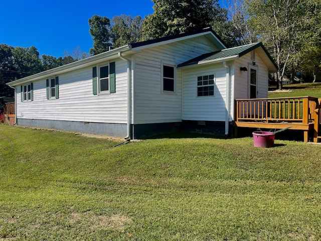 view of side of home featuring a lawn and a deck