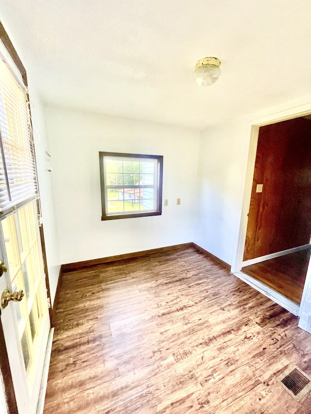 unfurnished room with hardwood / wood-style flooring