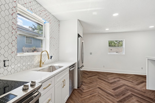 kitchen featuring white cabinets, dark parquet floors, sink, appliances with stainless steel finishes, and decorative backsplash