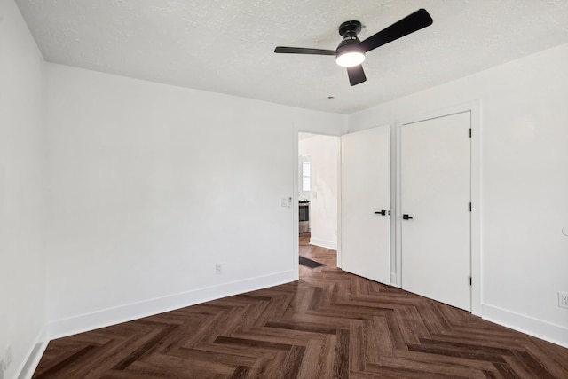 unfurnished bedroom with a closet, a textured ceiling, ceiling fan, and dark parquet flooring