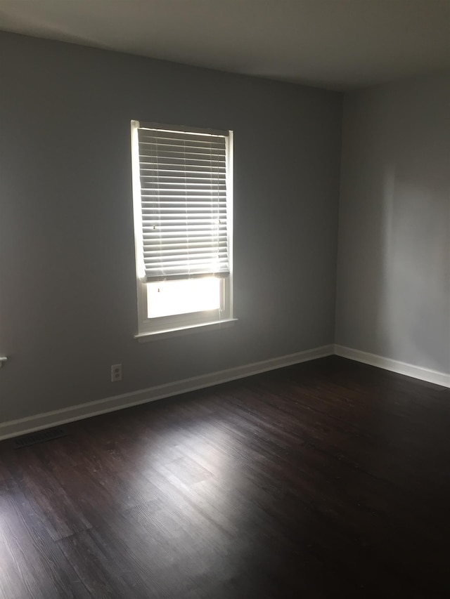 unfurnished room with dark hardwood / wood-style flooring