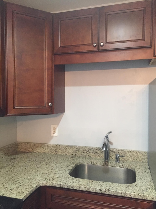 kitchen featuring sink and light stone countertops