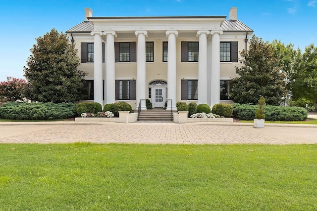 neoclassical home featuring a front lawn