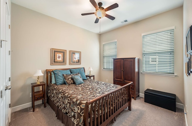 bedroom with ceiling fan, light carpet, and multiple windows