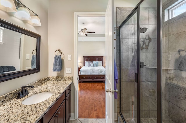 bathroom with vanity, hardwood / wood-style floors, ceiling fan, and a shower with shower door