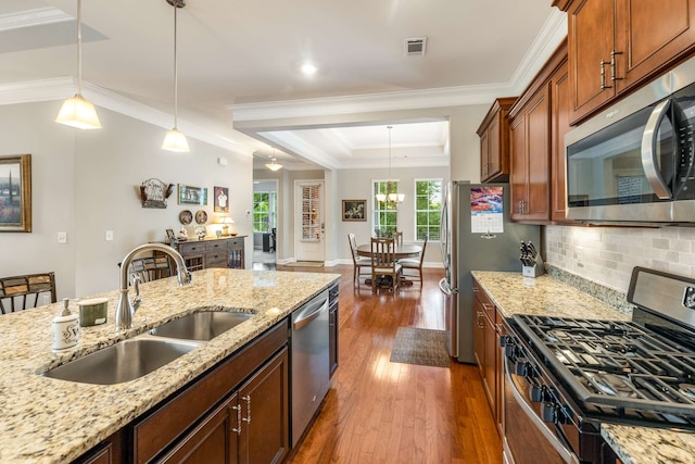 kitchen featuring sink, appliances with stainless steel finishes, light stone countertops, crown molding, and dark hardwood / wood-style flooring