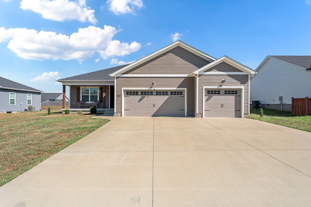 view of front facade featuring central AC, a front lawn, and a garage