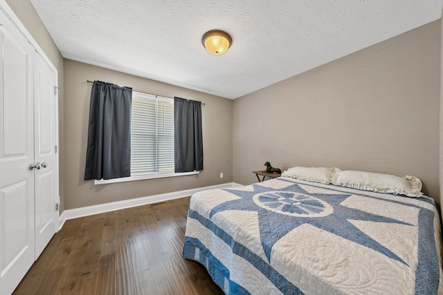 bedroom featuring a textured ceiling, a closet, and dark wood-type flooring