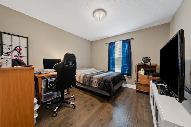 bedroom with a textured ceiling and dark hardwood / wood-style floors