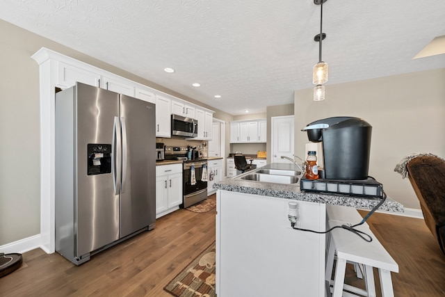 kitchen with white cabinetry, sink, stainless steel appliances, and dark hardwood / wood-style flooring