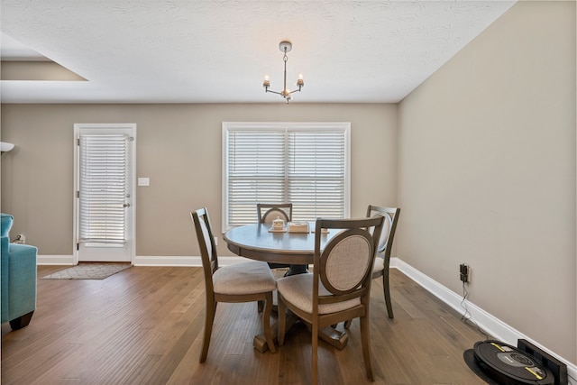 dining room with a notable chandelier, a textured ceiling, and hardwood / wood-style flooring