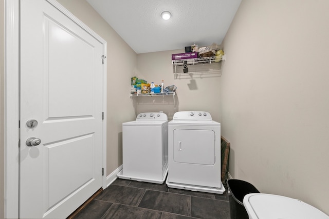 washroom featuring a textured ceiling and washing machine and clothes dryer