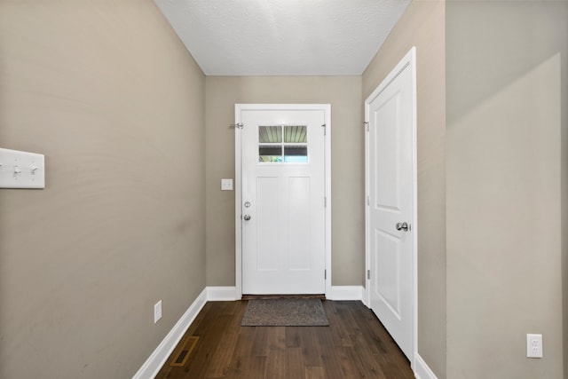 doorway featuring a textured ceiling and dark wood-type flooring