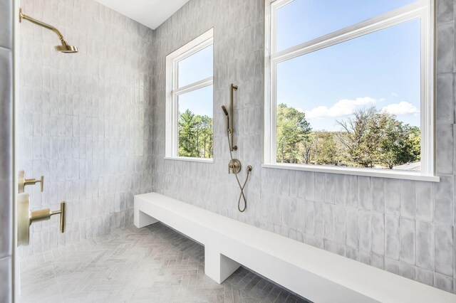 bathroom featuring a shower, tile walls, parquet floors, and a wealth of natural light